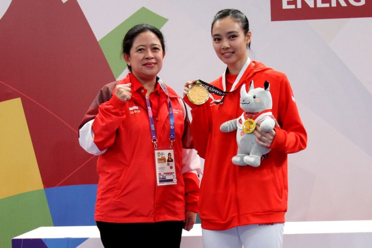 Menko PMK Puan Maharani mengalungkan medali emas ke alet wushu andalan Indonesia Lindswell Kwok dalam gelaran Asian Games 2018, di Jakarta, Senin (20/8/2018). 