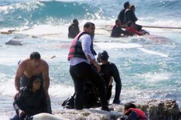 Penjaga pantai Yunani menyelamatkan para imigran yang kapalnya terdampar di lepas pantai Pulau Rhodes, Laut Aegean, Senin (20/4/2015).