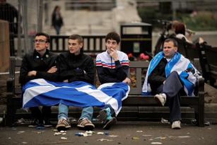 Para pendukung kemerdekaan Skotlandia duduk dengan lesu di sebuah taman di kota Glasgow, setelah hasil referendum menunjukkan sebagian besar rakyat memilih tetap berada di bawah bendera Inggris Raya.