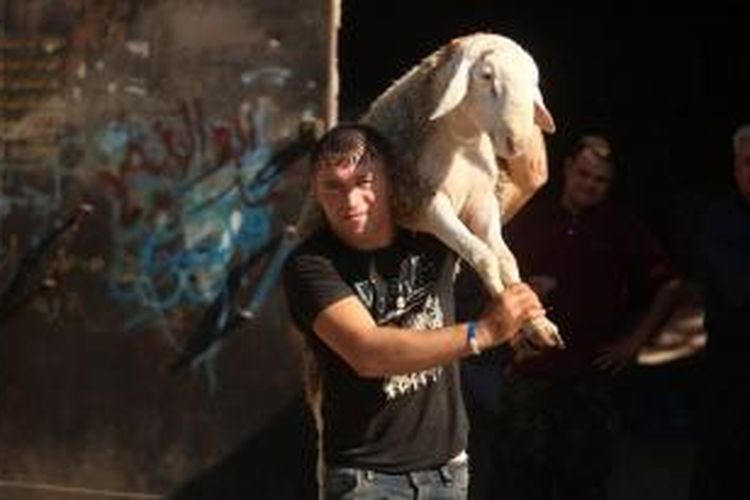 Seorang warga Jalur Gaza membawa seekor kambing untuk dikurbankan dalam hari raya Idul Adha, Sabtu (4/10/2014). Untuk pertama kalinya sejak 1981 dua hari raya besar Islam dan Yahudi yaitu Idul Adha dan Yom Kippur jatuh di hari yang sama.