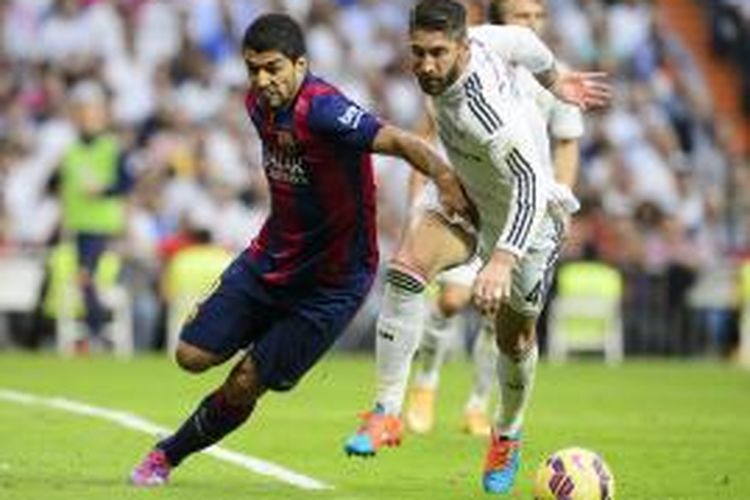 Penyerang Barcelona, Luis Suarez (kiri), berebut bola dengan bek Real Madrid, Sergio Ramos, pada pertandingan Primera Division, di Santiago Bernabeu, Sabtu (25/10/2014).