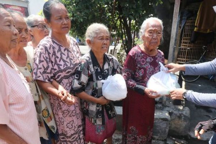 Warga antre untuk mendapatkan bantuan sembako di Kelurahan Pojok, Kota Kediri, Jawa Timur, Selasa (07/04). 