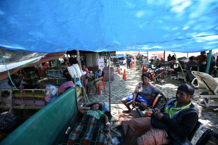 Pasien Rumah Sakit Anuta Pura terpaksa dirawat di halaman rumah sakit  akibat gempa bumi yang mengguncang Kota Palu, Sulawesi Tengah, Minggu (30/9/2018). Gempa bermagnitudo 7,4 mengakibatkan ribuan bangunan rusak dan sedikitnya 420 orang meninggal dunia.
