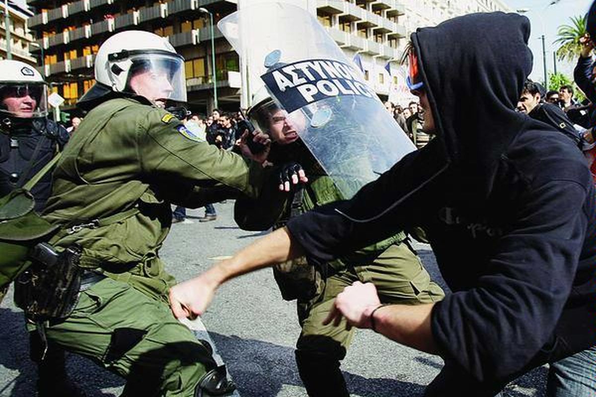 Para polisi bentrok dengan demonstran di Athena, Rabu (24/2). Pengurangan anggaran pengeluaran pemerintah membuat warga Yunani melakukan protes karena pengurangan itu berdampak pada penurunan gaji pegawai pemerintah.
