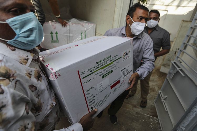 Foto tertanggal 12 Januari 2021 menampilkan petugas medis memindahkan kotak berisi vaksin Covid-19 dari mobil boks ke ruang pendingin di Civil Hospital, Ahmedabad, India.
