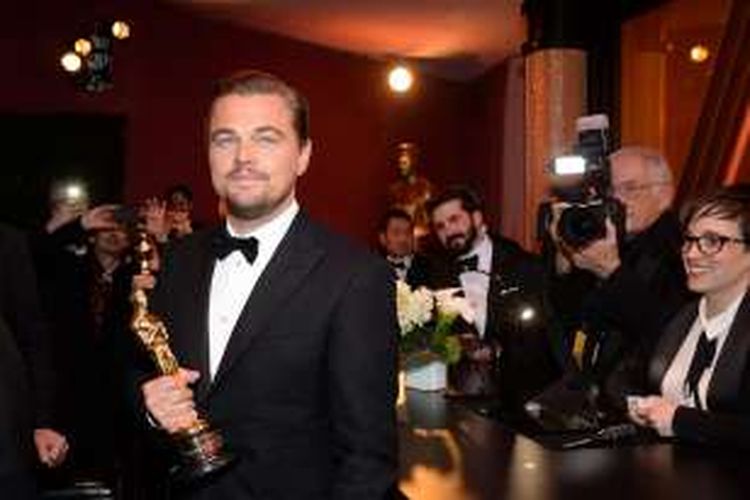 Leonardo DiCaprio berfoto bersama piala Oscar aktor terbaik saat menghadiri acara Governors Ball di Hollywood & Highland Center, Hollywood, California, Minggu (28/3/2016).