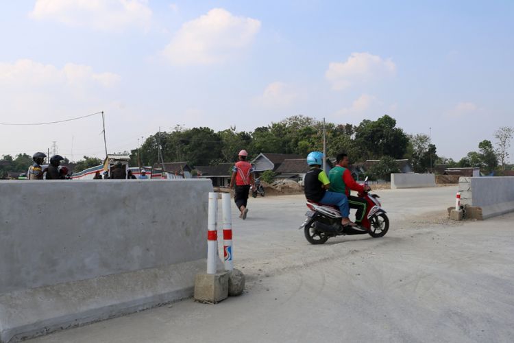 Warga melintas pada proyek tol Solo-Ngawi, Jawa Timur, Senin (4/6/2018). Terhitung mulai 8 Juni 2018 aatau H-7 Lebaran, Jalan tol fungsional tersebut sudah dapat dilalui pemudik.