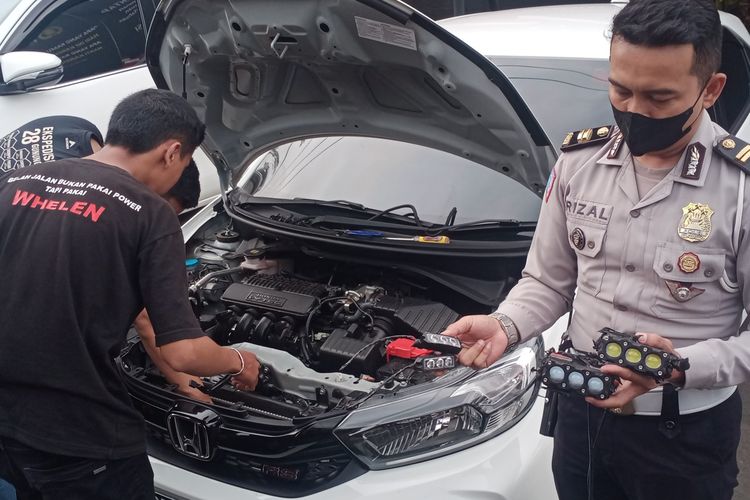 Satlantas Polresta Malang Kota melepas alat lampu strobo dan sirine dari mobil Honda Brio berwarna putih dengan nomor polisi B 2509 FIZ di Mapolresta Malang Kota pada Selasa (17/5/2022) siang. 