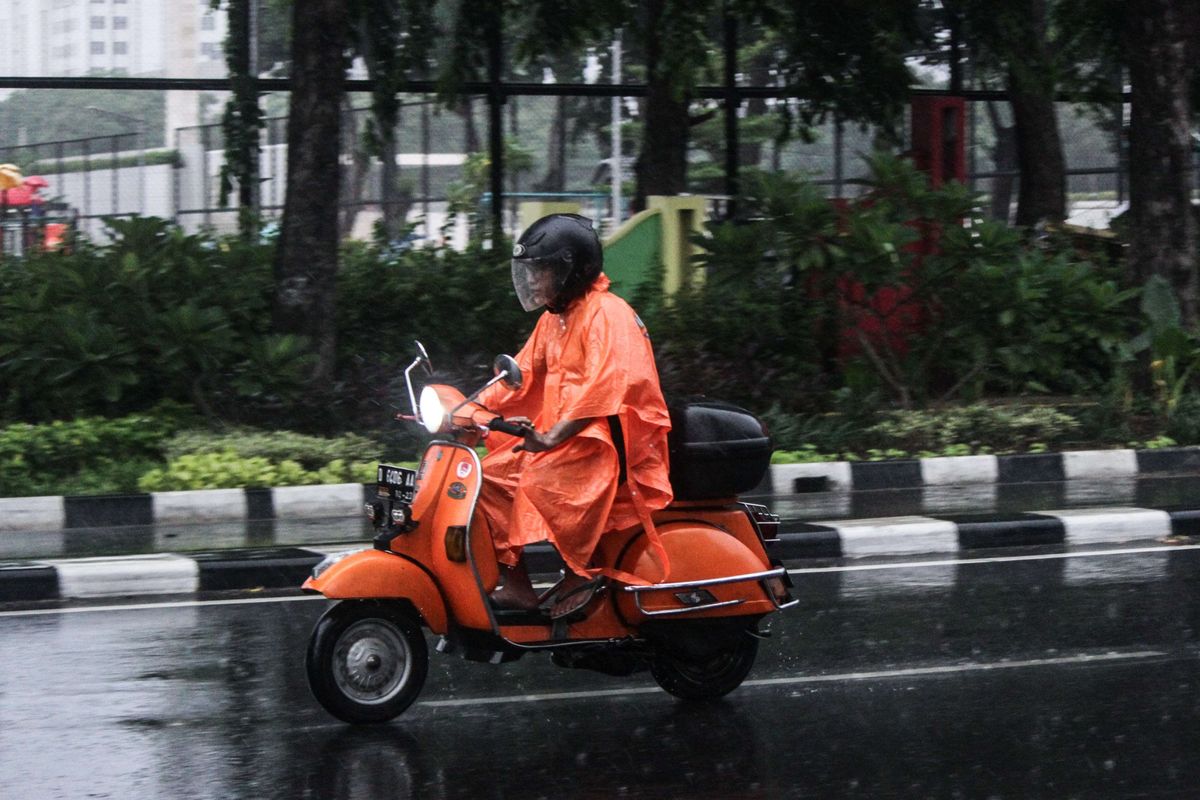 Pengendara sepeda motor mengenakan jas hujan saat terjadi hujan di Jalan Katedral, Sawah Besar, Jakarta Pusat, Minggu (22/12/2019). Badan Meteorologi, Klimatologi, dan Geofisika (BMKG) memberikan informasi dini cuaca ektrem yang akan melanda sejumlah wilayah di Indonesia pada hari Minggu (22/12/2019), dan Senin (23/12/2019).
