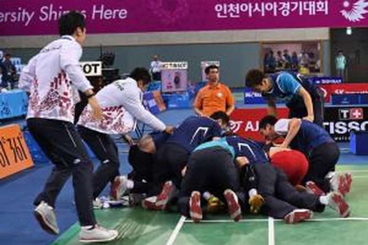 Para pemain bulu tangkis Kroea Selatan berlari memasuki lapangan setelah Lee Hyun-il memenangi pertandingan terakhir melawan Gao Huan (Tiongkok) pada laga final nomor beregu putra Asian Games 2014 di Incheon, Korea Selatan, Selata (23/9/2014).