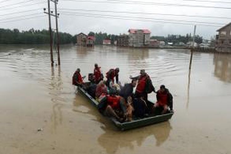 Para prajurit India menggunakan perahu karet menyelamatkan warga yang terjebak banjir di pinggiran kota Srinagar, Kashmir. Banjir bandang menyebabkan ratusan desa di Kashmir, India dan Punjab, Pakistan terendam.