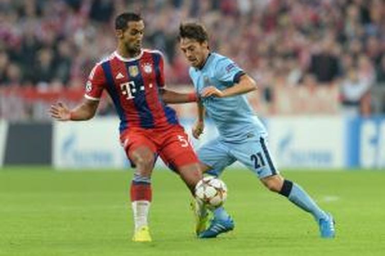 Gelandang Manchester City, David Silva (kanan) saat berebut bola dengan bek Bayern Muenchen, Mehdin Benatia, pada matchday pertama Grup E Liga Champions di Stadion Allianz Arena, Rabu (17/9/2014). 