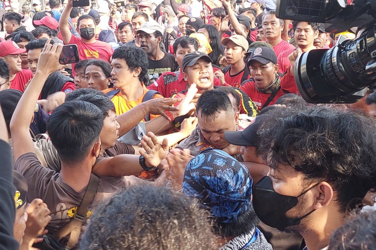 Personel kepolisian saat terlibat aksi dorong-mendorong dengan massa aksi yang merupakan pendukung Haris Azhar dan Fatia Maulidiyanti di Pengadilan Negeri (PN) Jakarta Timur, Kamis (8/6/2023).