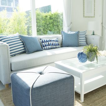 Ilustrasi ruang tamu bergaya pantai dengan warna biru pastel.