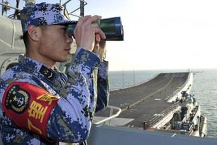 Seorang pelaut China sedang memantau situasi dari atas geladak kapal induk Liaoning dalam sebuah latihan pada Nomber lalu di Laut China Selatan.