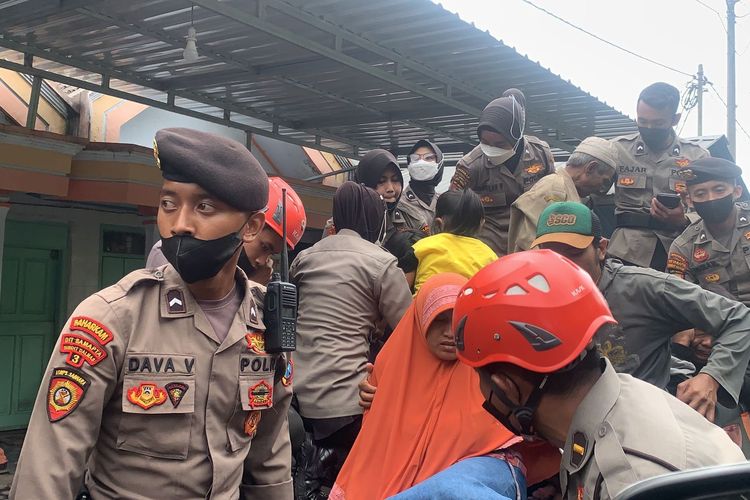 Anggota kepolisian membantu warga di lokasi bencana erupsi Gunung Semeru, Mingfu (5/12/2021). 