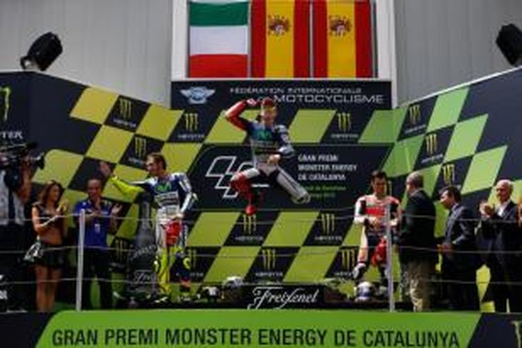 Pebalap Movistar Yamaha asal Spanyol, Jorge Lorenzo (tengah), merayakan kemenangan pada GP Catalunya saat berada di podium Sirkuit de Barcelona, Minggu (15/6/2015).