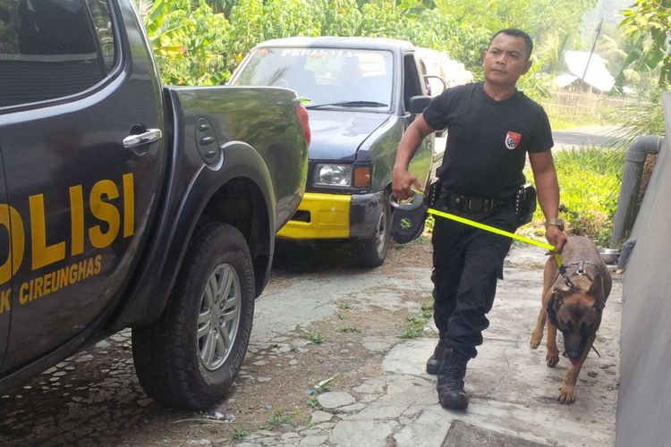 Anggota Polres Cianjur membawa anjing pelacak di lokasi perampokan di wilayah Polres Sukabumi Kota, Selasa (19/9/2017).