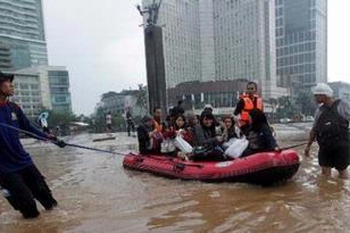 Warga menggunakan perahu karet menembus banjir di kawasan Bundaran Hotel Indonesia, Jakarta, Kamis (17/1/2013). Banjir tersebut mengakibatkan akses Jalan Jenderal Sudirman - MH Thamrin lumpuh. 