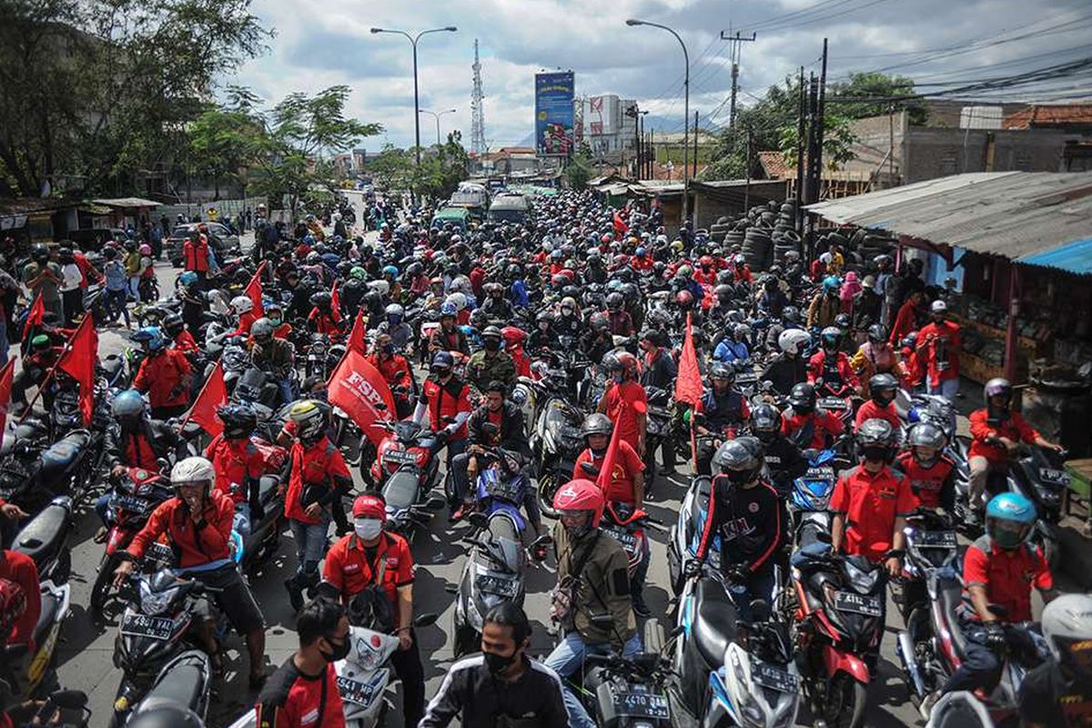 Ratusan buruh memblokir jalan nasional Bandung-Garut-Tasikmalaya saat melakukan aksi di Rancaekek, Kabupaten Bandung, Jawa Barat, Selasa (6/10/2020). Aksi tersebut merupakan buntut dari penolakan buruh terhadap pengesahan UU Cipta Kerja yang telah disahkan oleh DPR.