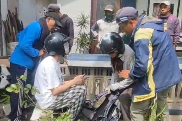 Sejumlah warga mengevakuasi dua wisatawan asal China usai motor matic yang mereka naiki terjun ke sawah. 