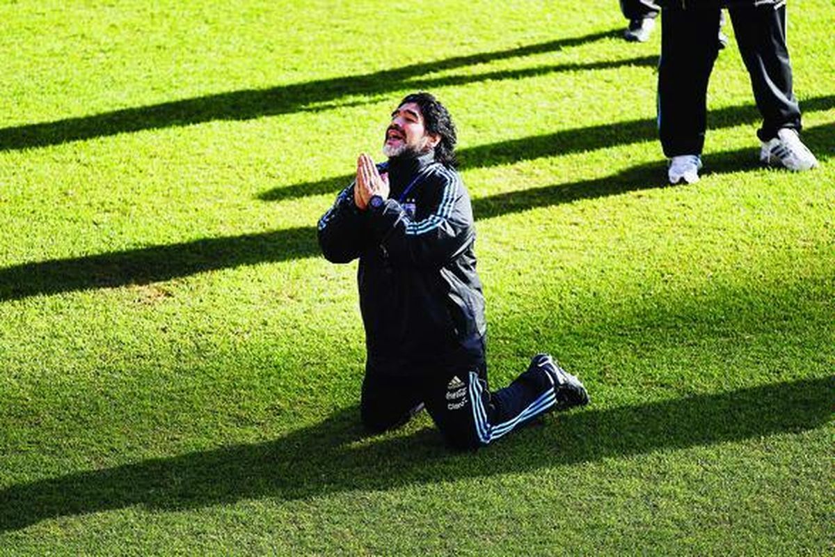 Pelatih Argentina Diego Maradona berlutut di hadapan para wartawan seolah memohon ampun atas pertanyaan-pertanyaan wartawan yang keras dan pedas di Pretoria, Afrika Selatan, Selasa (15/6).