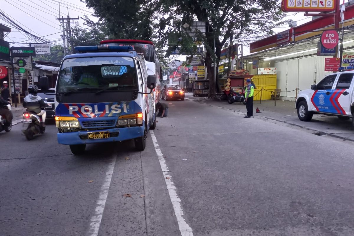 Petugas kepolisian mengerankan mobil derek untuk mengevakuasi bus pariwisata yang tersangkut separator di Jalan M Yusuf, Sukamajaya, Depok pada Rabu (3/7/2022). (Istimewa).