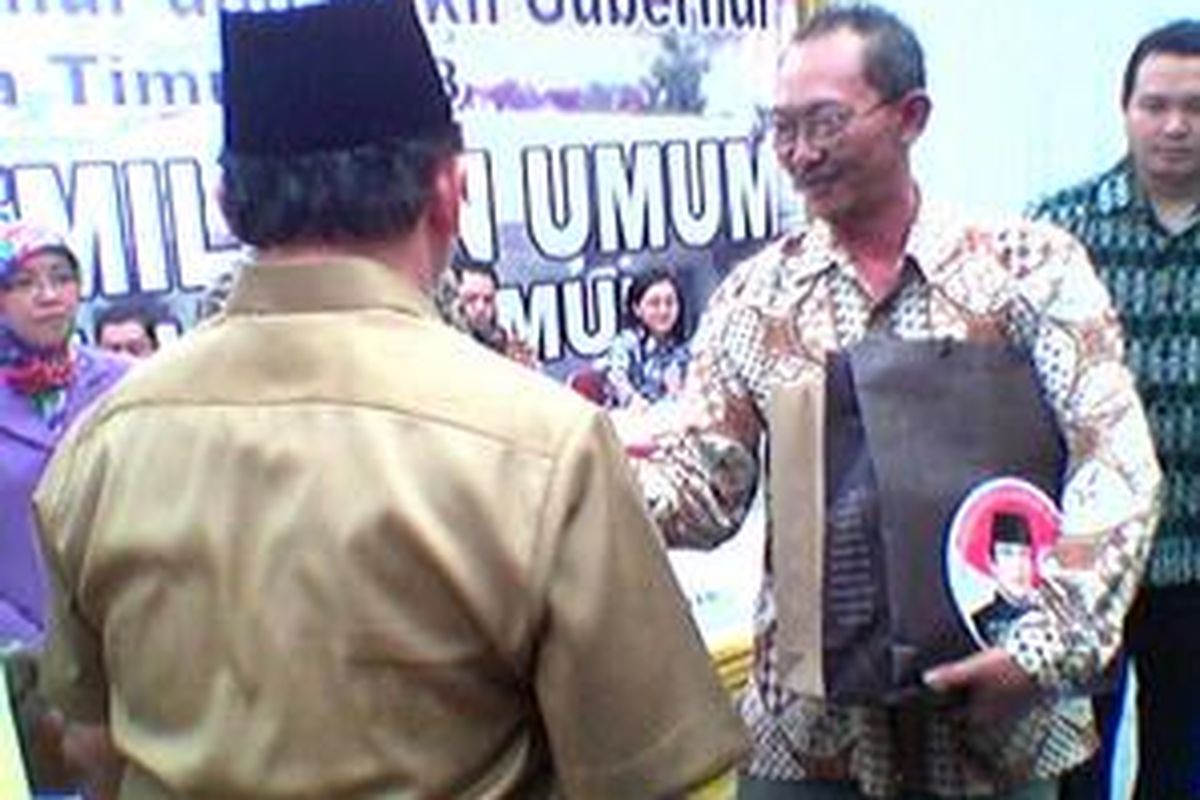 Ketua KPU Jawa Timur Wahyudi Purnomo (kanan) menerima berkas pendaftaran pasangan calon gubernur-wakil gubernur dari Golkar, Soenarjo-Ali Maschan Moesa di Surabaya, Sabtu  (10/5). Soenarjo-Ali merupakan pasangan kedua yang menyerahkan berkas pendaftaran ke KPU.