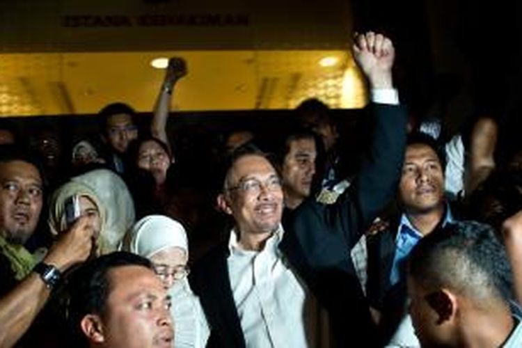 Tokoh oposisi Malaysia, Anwar Ibrahim, disambut para pendukungnya saat meninggalkan gedung Pengadilan Tinggi Malaysia di Putrajaya, Jumat (7/3/2014), usai mendengarkan putusan pengadilan yang mengabulkan banding pemerintah. 