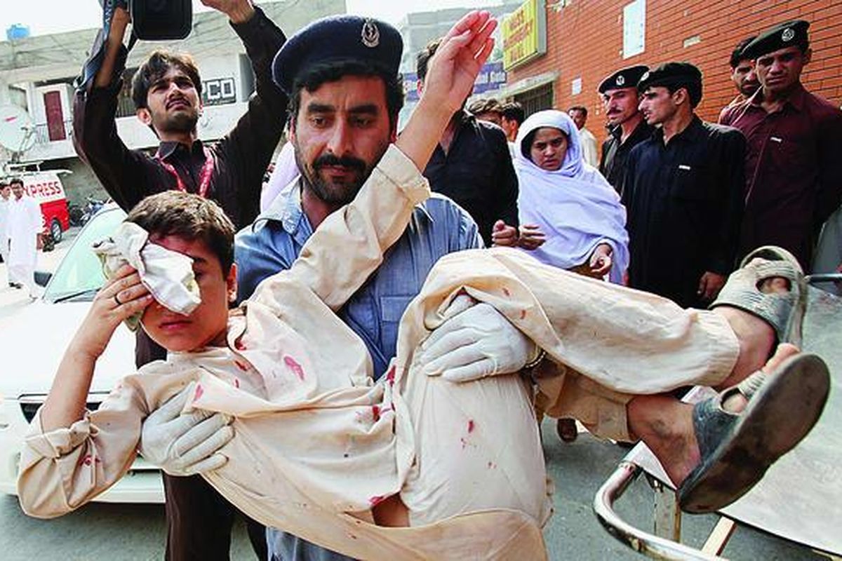 Bocah laki-laki  yang cedera dibopong petugas ke rumah sakit setelah insiden ledakan bom di Peshawar, Pakistan, Kamis  (11/8). Seorang perempuan pelaku bom bunuh diri meledakkan diri di dekat polisi yang sedang menjaga lokasi ledakan bom beberapa saat sebelumnya. Insiden ledakan ganda yang jarang terjadi ini menewaskan sedikitnya 10 orang.