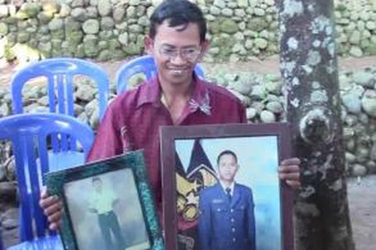 Kerabat korban memegang foto Serka Sutrisno, Rabu (1/7/2015). 