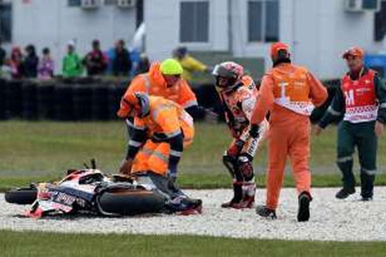 Pebalap Repsol Honda Team asal Spanyol, Marc Marquez (tiga dari kanan), dibantu para marshal setelah mengalami kecelakaan saat balapan GP Australia di Sirkuit Phillip Island, Minggu (23/10/2016).