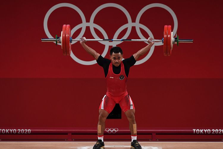 Lifter Indonesia Eko Yuli Irawan melakukan angkatan snatch dalam kelas 61 kg putra Grup A Olimpiade Tokyo 2020 di Tokyo International Forum, Tokyo, Jepang, Minggu (25/7/2021). Eko Yuli berhasil mempersembahkan medali perak dengan total angkatan 302 kg.