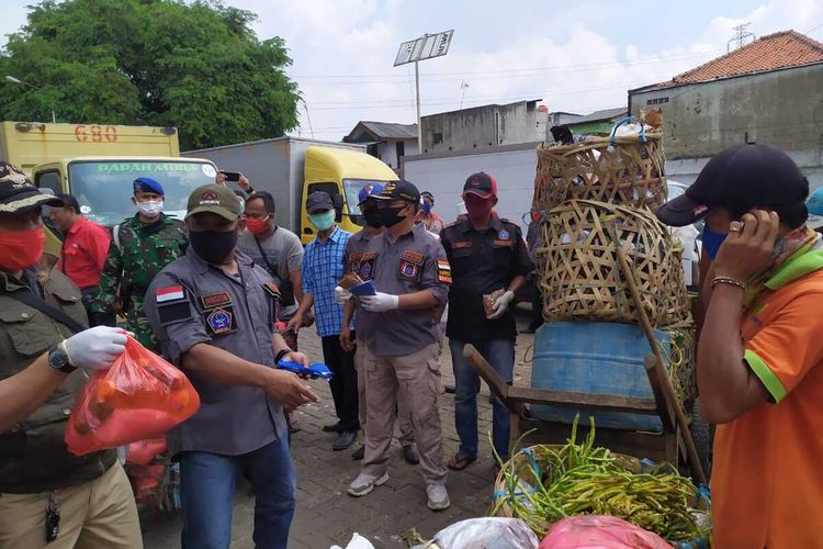 Anggota BPPKB Banten Cipinang Besar Selatan bersama TNI dan Polri beri bantuan 500 paket sembako kepada pedagang hingga kuli angkut di Pasar Ciplak, Jatinegara, Jakarta Timur, Senin (20/4/2020).