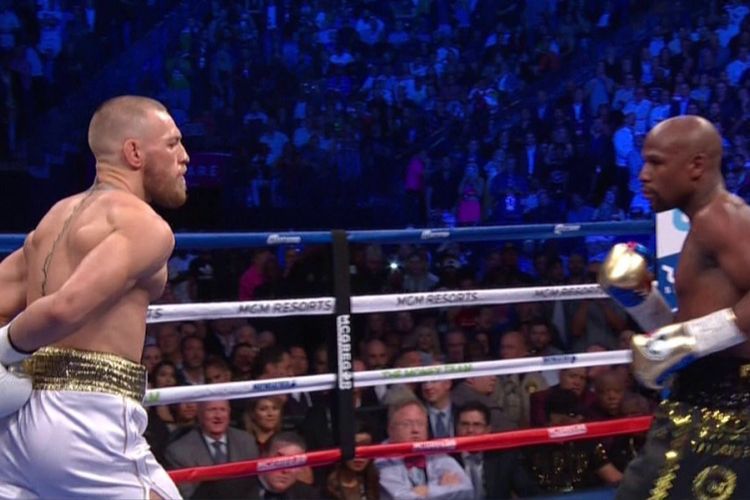 Conor McGregor tampak memanas-manasi Floyd Mayweather saat keduanya bertarung di Las Vegas, Sabtu (26/8/2017). 