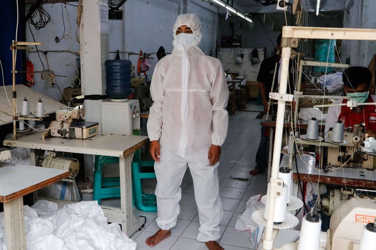 Pekerja menunjukkan alat pelindung diri buatan konveksi milik Riswan Halomoan di kawasan PIK, Penggilingan, Jakarta Timur, Kamis (26/3/2020). Konveksi ini memproduksi 1000 APD perhari pesanan dari berbagai rumah sakit untuk tenaga medis yang menangani pasien COVID-19.