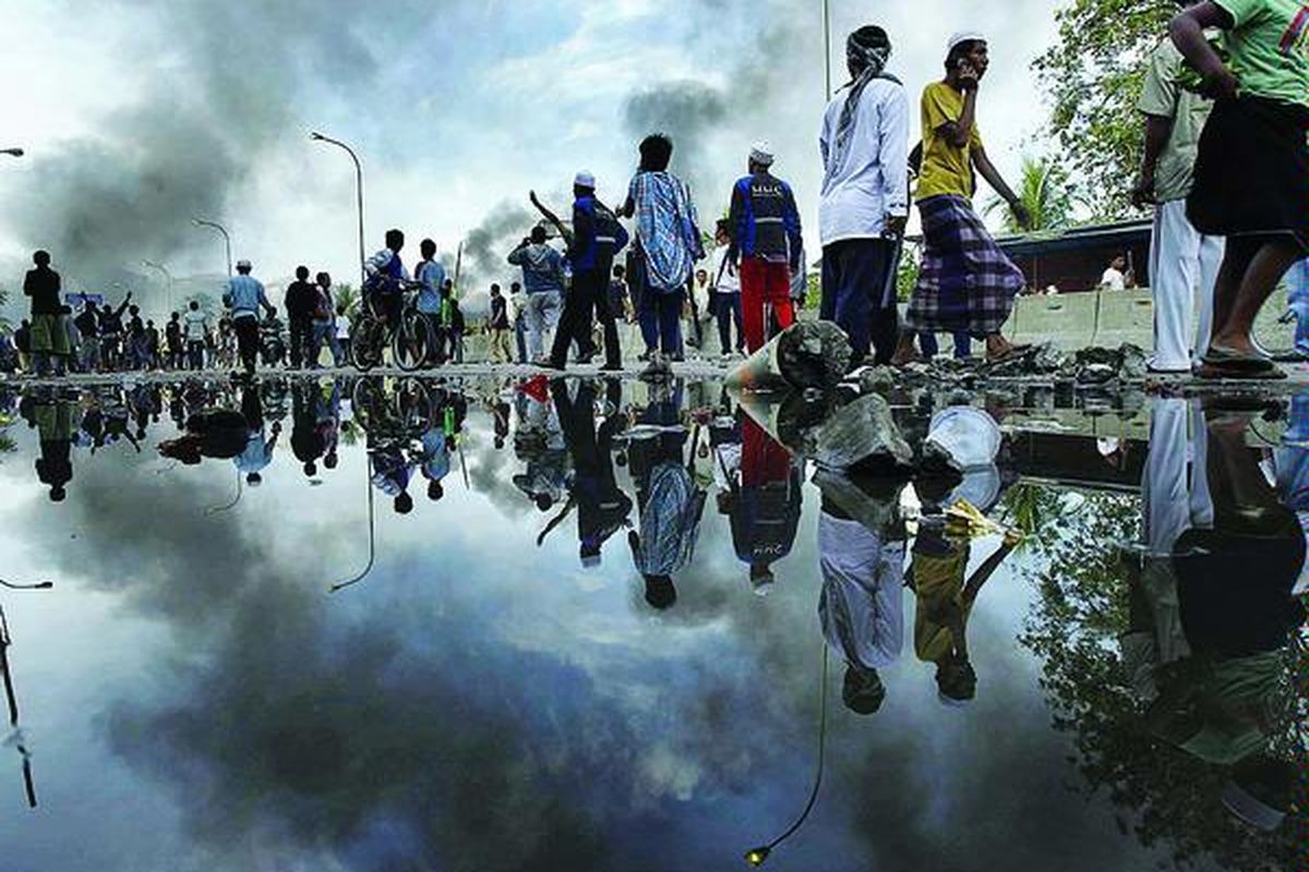 Warga meninggalkan lokasi bentrokan antara aparat keamanan dan warga dalam gusuran makam Mbah Priuk di Koja, Tanjung Priok, Jakarta Utara, Rabu (14/4).
