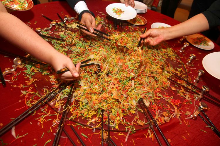 Salad yee sang yang telah dicampur dan diaduk secara serempak.