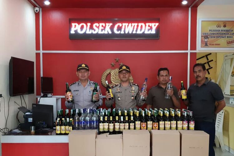 Kapolsek Ciwidey AKP Ivan Taufiq tengah memperlihatkan ratusan botol miras hasil razia jelang Pilpres dan Pileg 2019.