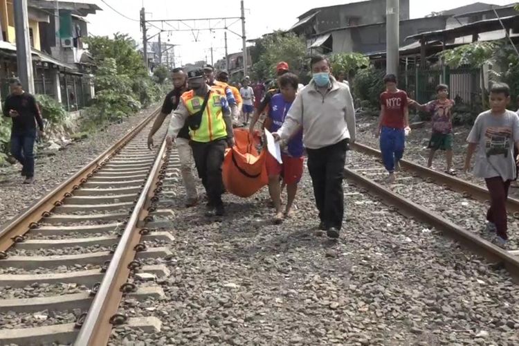 Jenazah seorang pria yang bunuh diri di perlintasan kereta api di dekat Stasiun Pesing, Grogol Petamburan, Jakarta Barat dievakuasi pada Senin (31/5/2021).