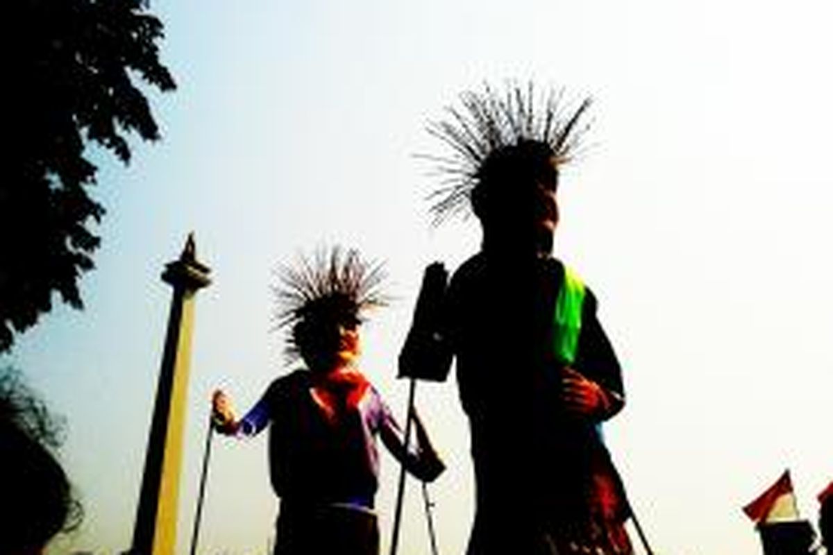 Sepasang ondel-ondel raksasa yang hadir di kawasan Tugu Monas, Jakarta, Minggu (18/8/2013) untuk memeriahkan Monas Jakarta Carnaval 2013