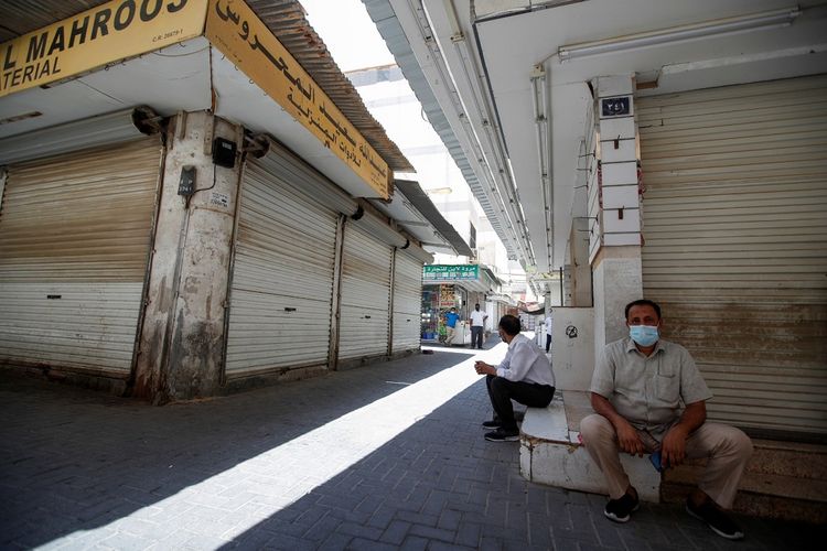 Para penjual duduk di luar toko mereka, ketika negara itu memasuki semi-lockdown selama dua minggu karena tingginya jumlah kasus dan kematian penyakit virus corona (COVID-19), di Manama, Bahrain, Kamis (3/6/2021). ANTARA FOTO/REUTERS/Hamad I Mohammed/WSJ/sa.