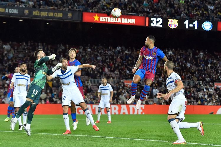 Penyerang Barcelona Memphis Depay (dua dari kanan) menyundul bola dalam laga pekan ke-12 Liga Spanyol 2021-2022 kontra Deportivo Alaves di Stadion Camp Nou, Minggu (31/10/2021).