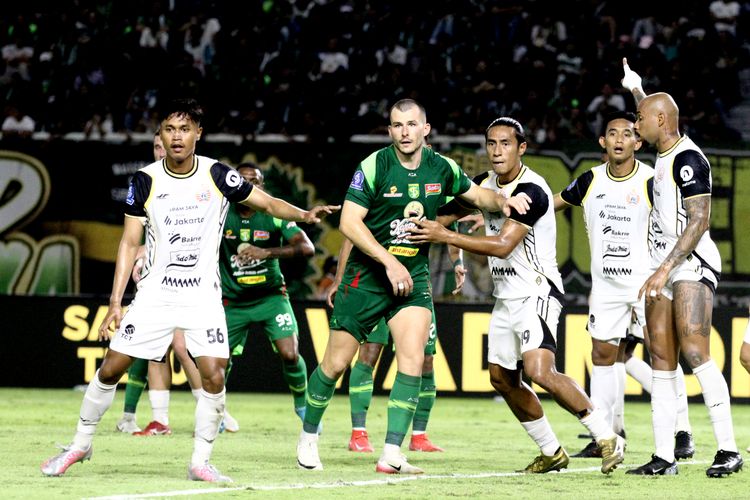 Pemain Persebaya Surabaya Milos Raikovic dijaga ketat pemain Persija Jakarta saat laga pekan ke-9 Super League 2025-2026 yang berakhir dengan skor 1-3 yang berlangsung di Stadion Gelora Bung Tomo Surabaya, Jawa Timur, Sabtu (18/10/2025) malam.