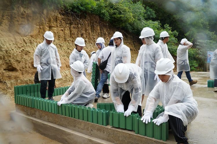 Relawan Bakti BUMN Batch VII bergotong royong bersama warga dalam pembangunan TK menggunakan eco blocks di Kampung Adat Prailiu Kabupaten Sumba Timur, Nusa Tenggara Timur.