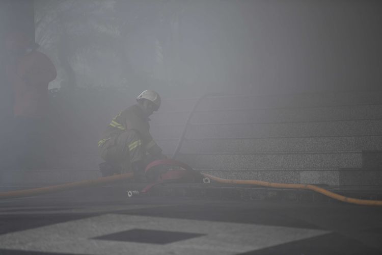 Petugas menerobos asap tebal saat  berusaha memadamkan  kebakaran yang terjadi di Gedung Cyber I, Mampang, Jakarta, Kamis (2/12/2021). Dinas Penanggulangan Kebakaran dan Penyelamatan Jakarta mengerahkan 100 personel beserta 22 unit mobil pemadam ke lokasi. Api berhasil dipadamkan dalam waktu 30 menit.