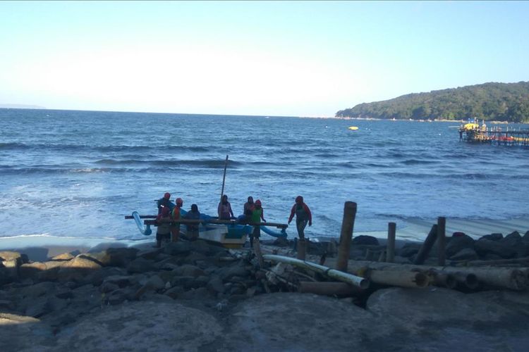 Nelayan gotong royong menurunkan perahu yang akan dipakai menebar jaring ke tengah laut, di Pantai Timur Pangandaran, Jumat (19/7/2019).