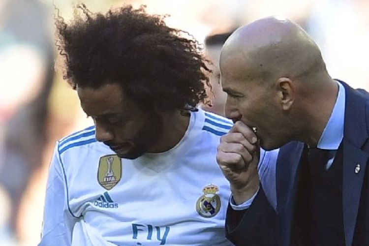 Bek kiri Real Madrid, Marcelo (kiri), sedang mendengarkan arahan dari pelatihnya, Zinedine Zidane, pada laga pekan ke-17 La Liga Spanyol melawan FC Barcelona, di Stadion Santiago Bernabeu, Sabtu (23/12/2017).