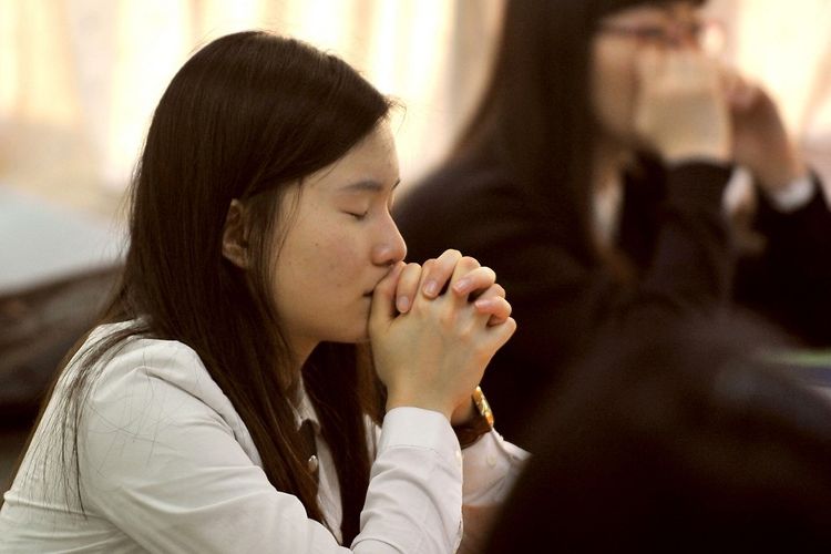 Seorang siswa Korea Selatan berdoa sebelum mengikuti Tes Kemampuan Skolastik Perguruan Tinggi, ujian standar untuk masuk perguruan tinggi, di sebuah ruang ujian di Seoul pada tanggal 13 November 2008.
