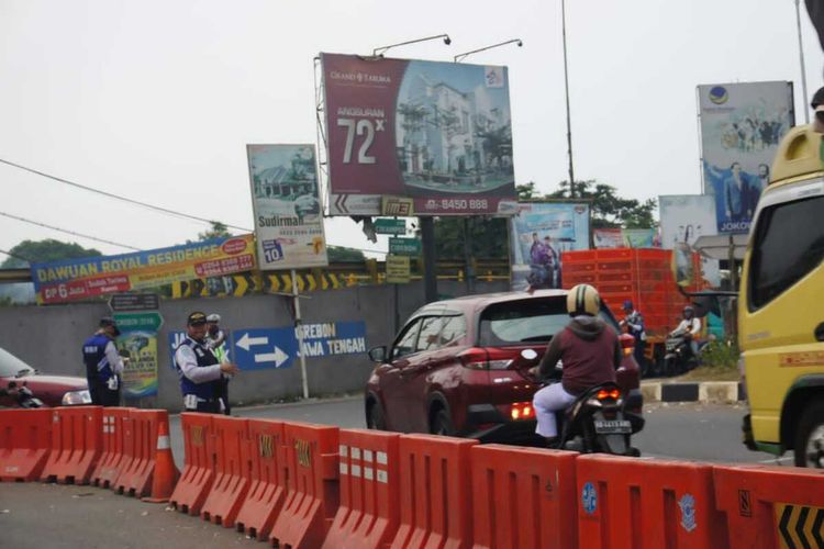 Petugas Dinas Perhubungan dan Kepolisian tengah mengatur lalu lintas di Simpang Jomin, Karawang, Jawa Barat.